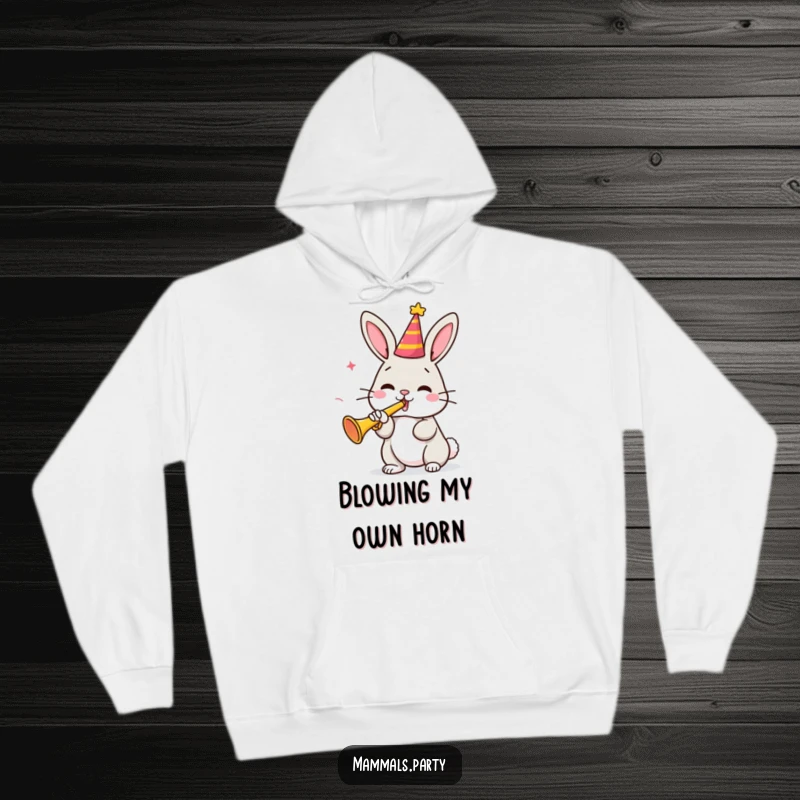 Funny bunny character in a party hat blowing a small trumpet, depicted on a cozy hoodie, radiating cheerful vibes for a funny gift.
