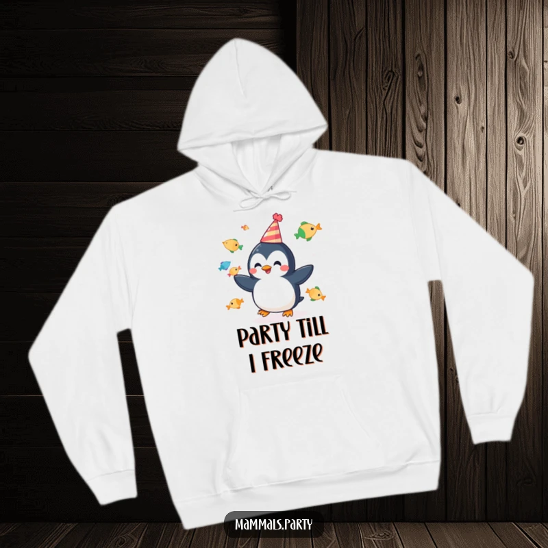 Funny hoodie featuring a cheerful penguin juggling fish while wearing a party hat, perfect for cozy festive fun.